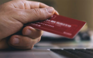 Hand holding a red credit card